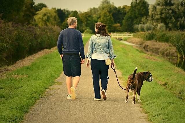A couple walking their rescued dog down a path.