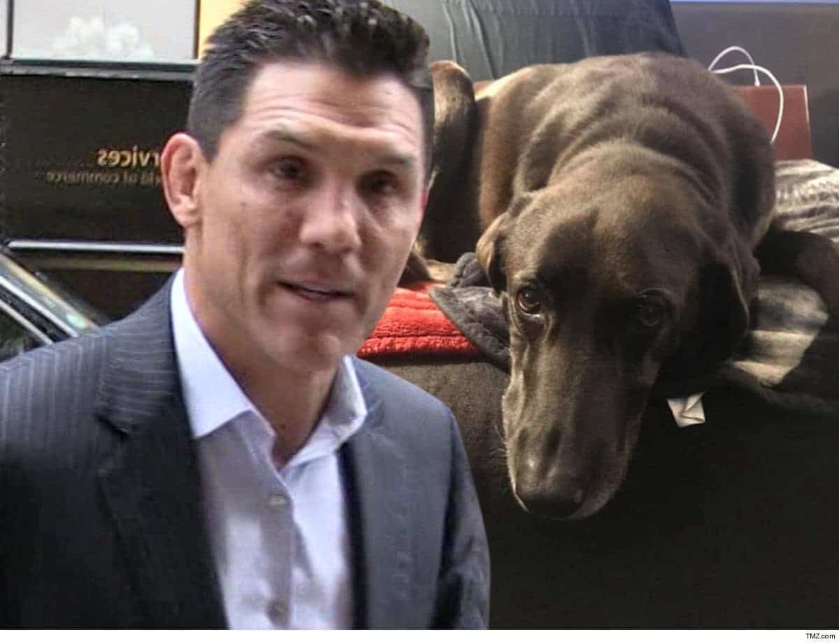 A man in a suit standing next to a dog.