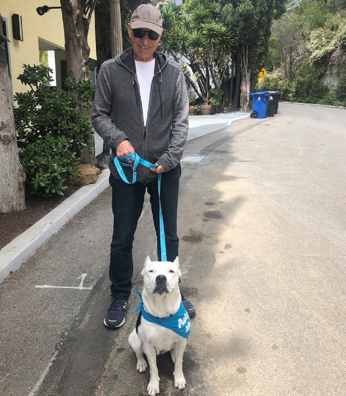 A man with a white dog on a leash.